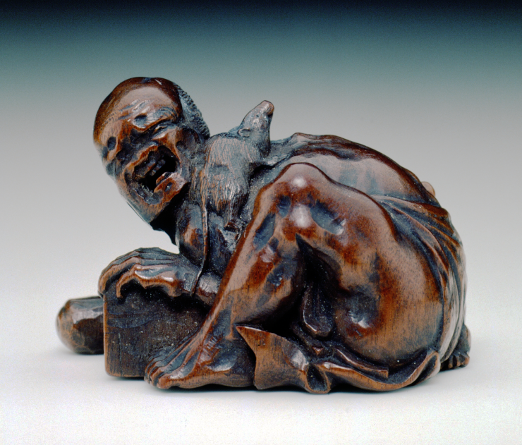 A Japanese statue of a rat-catcher upset at the rodent crawling over his neck instead of into his trap